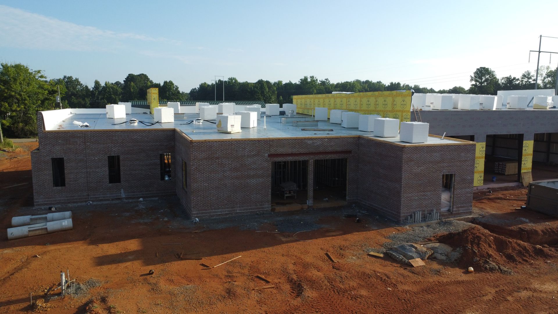 Aerial view of the Hartselle fire station under construction — completed brick masonry and roof insulation staged for installation