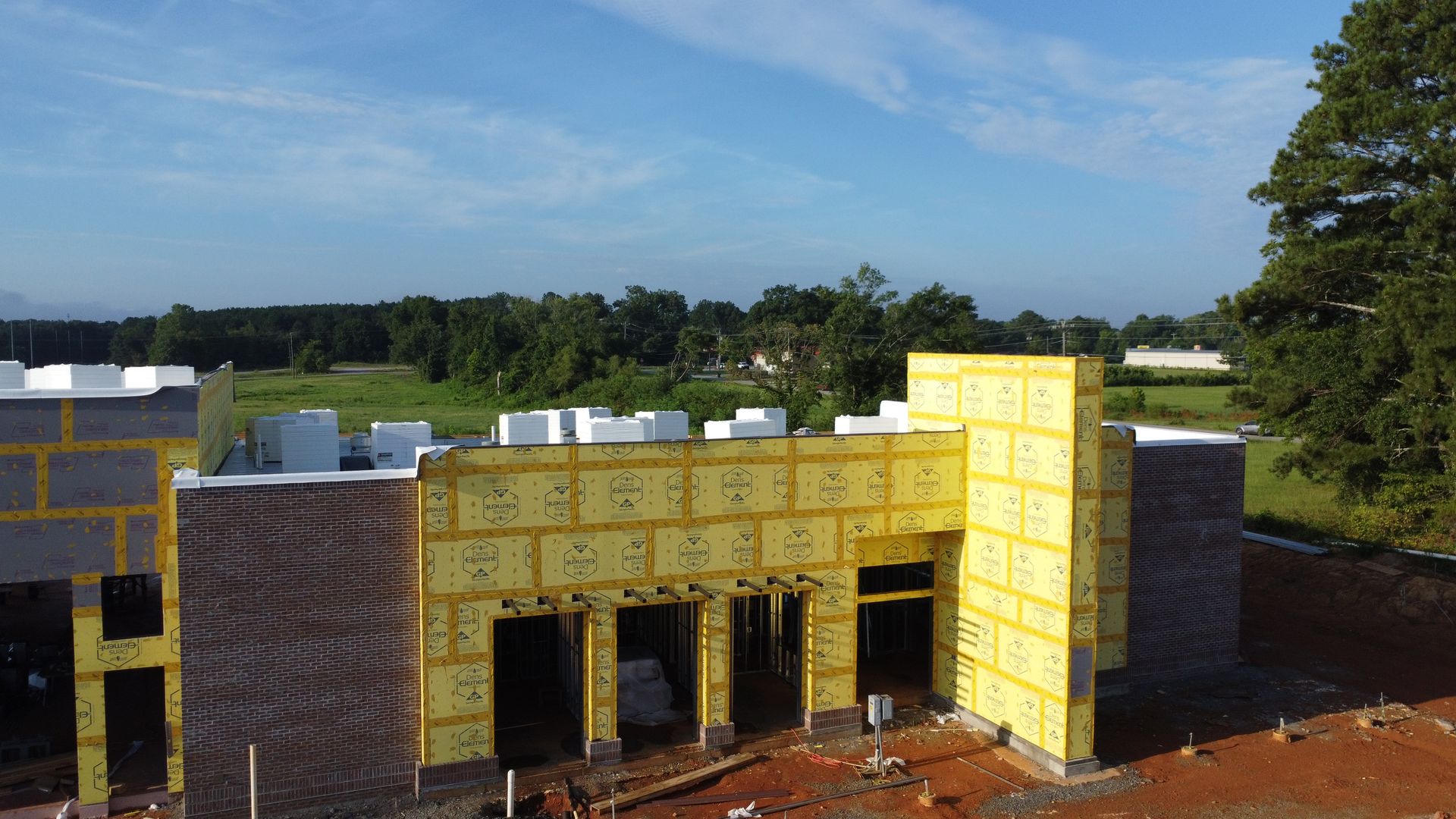 Hartselle fire station under construction — brick and sheathed front elevation with apparatus bay openings